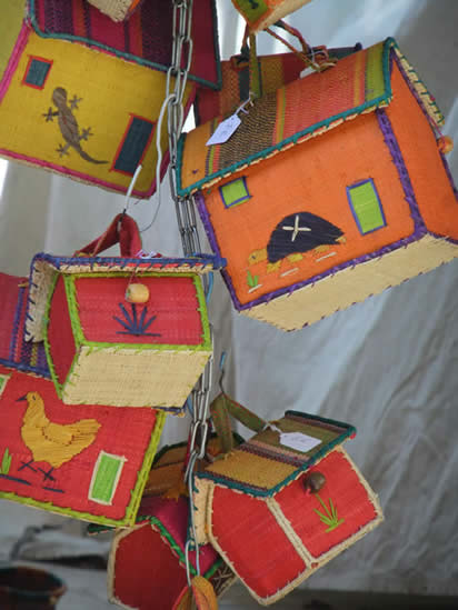 Baskets in the shape of houses with pictures of lizzards and chickens