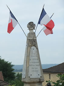 Monument to those who died in the World War from Limeuil with three french flags flying